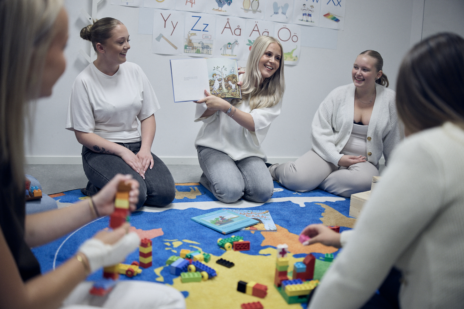 Tre elever som sitter och läser i en barnbok.