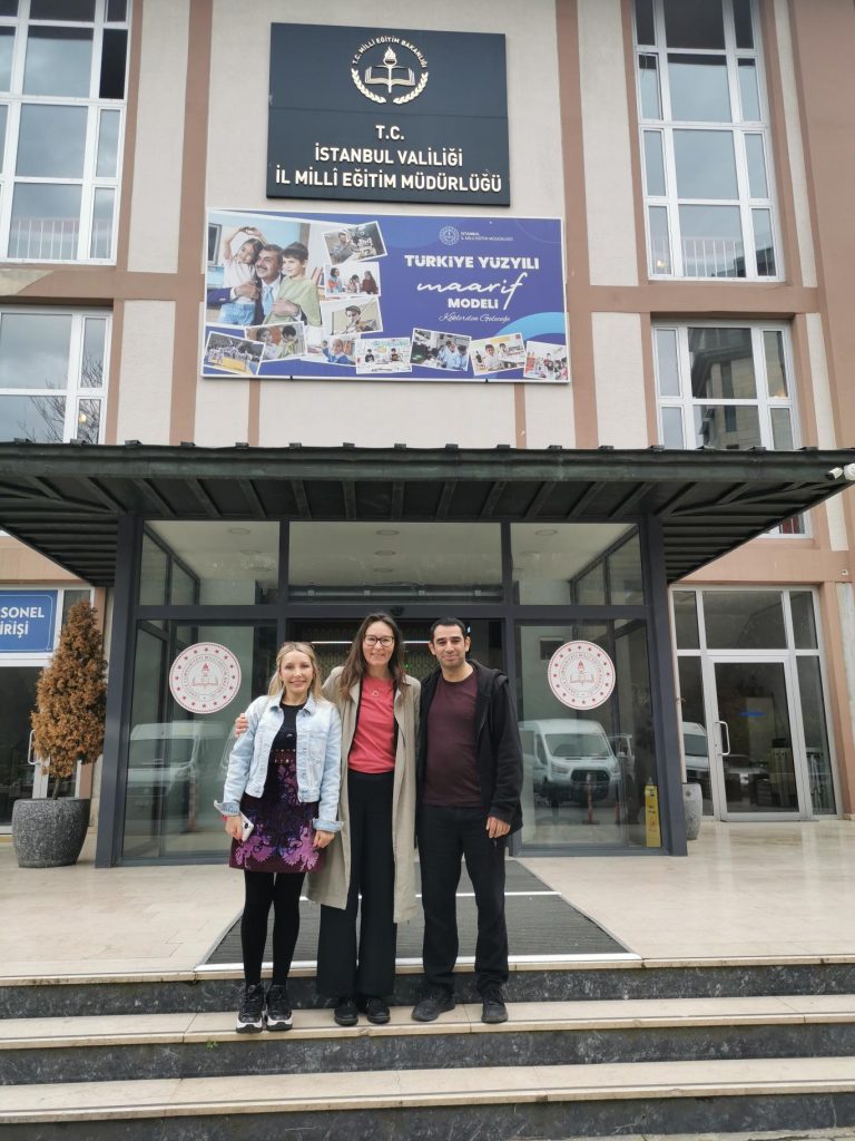 Tre personer står framför Istanbul utbildningsdirektoratets byggnad.