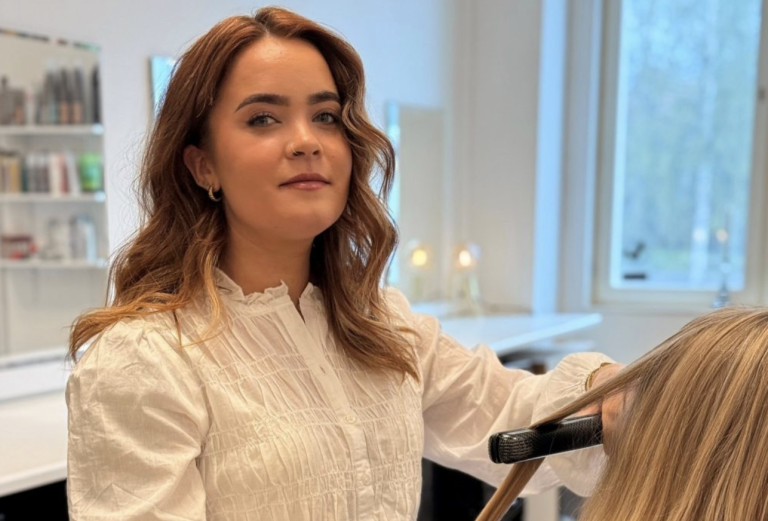 Bild på Amanda när hon stylar kunds hår.